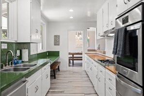 Enjoy cooking in this well-equipped kitchen with a stainless steel refrigerator, oven, and double sink.
