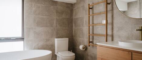 A modern bathroom with a toilet, sink, and bathtub.