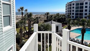 A beachfront property with a pool, palm trees, and a view of the ocean. - 3 Summer Dunes - Renovated Ocean View Beach House! (Isle of Palms)