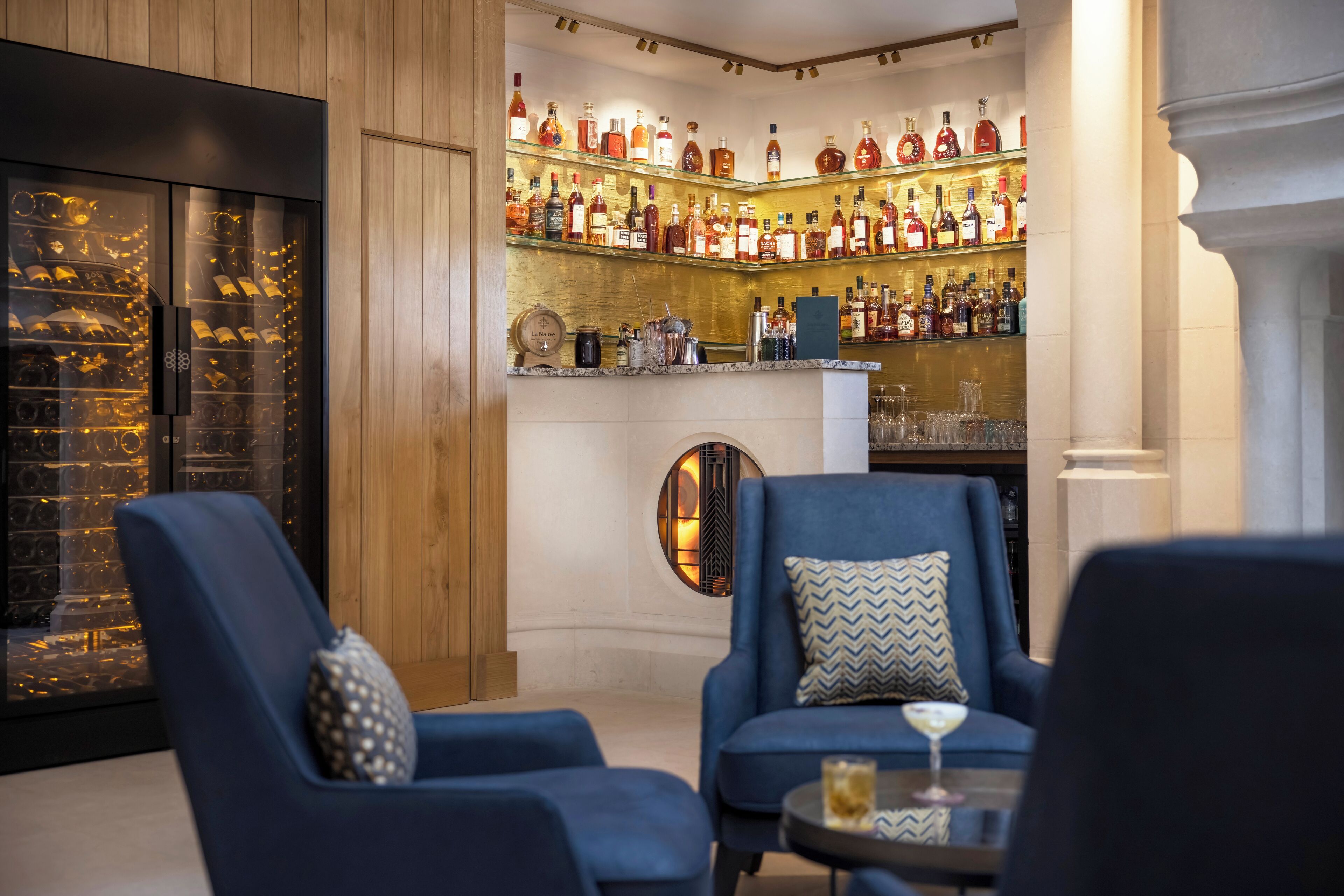 A bar area with a wine rack, seating, and a fireplace.