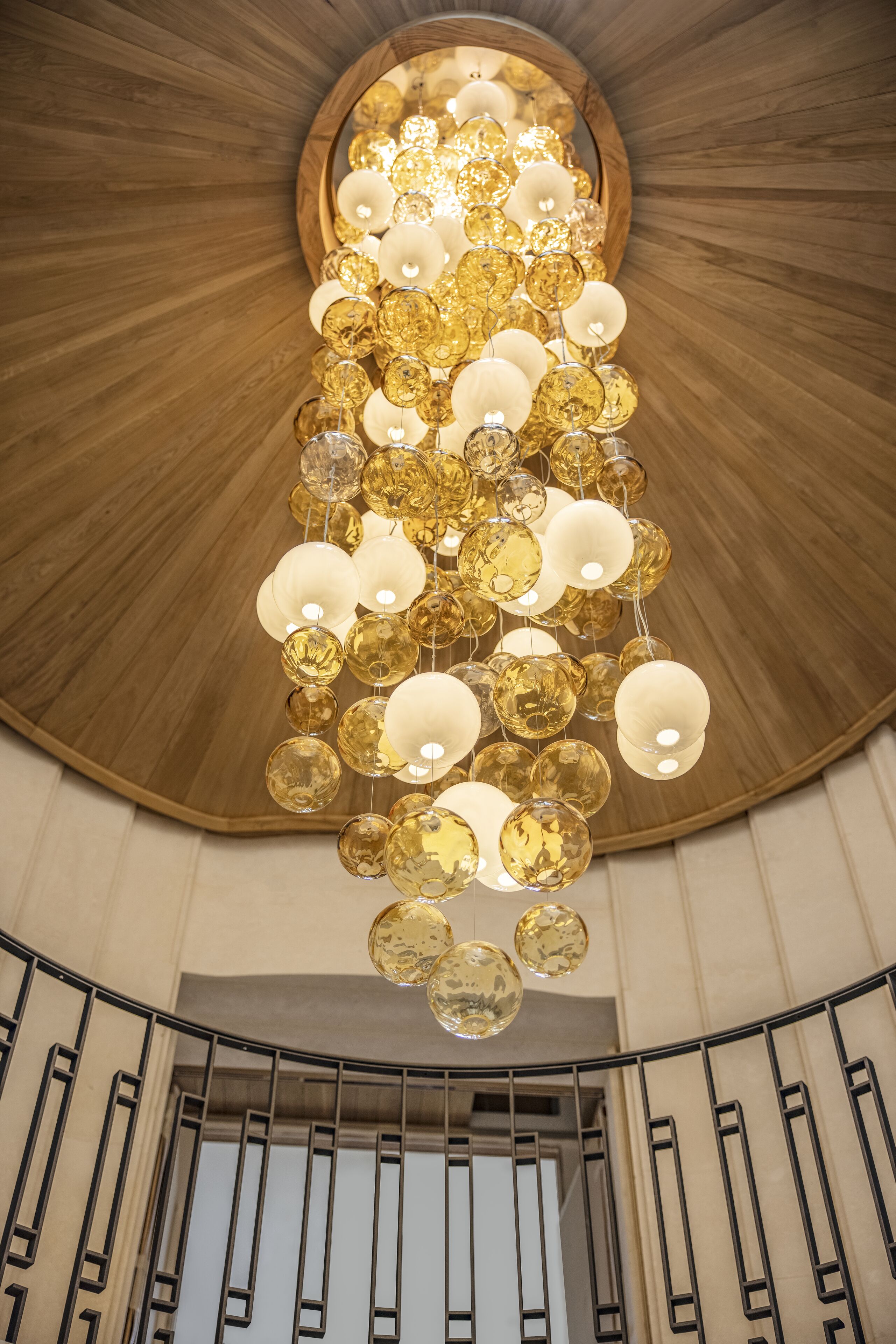 Un magnifique escalier d’honneur surmonté d’un lustre moderne.