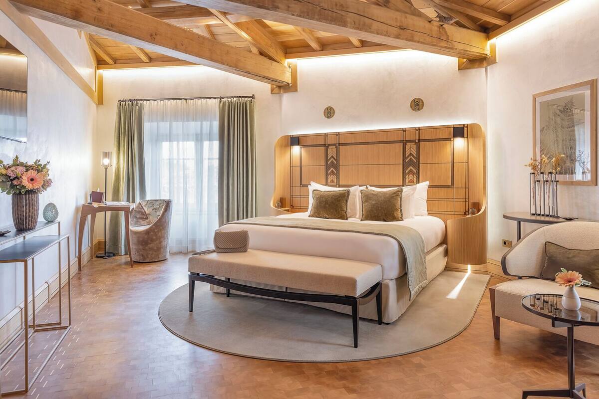 Une chambre moderne avec un grand lit, un tapis rond, un bureau et une chaise.