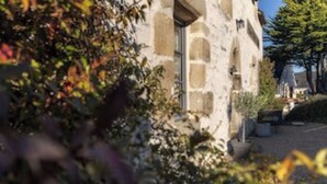 Un bâtiment en pierre doté d’une cour intérieure, entouré de verdure.