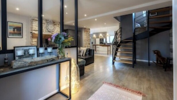 Un intérieur moderne comprenant une cuisine, un coin repas et un escalier.