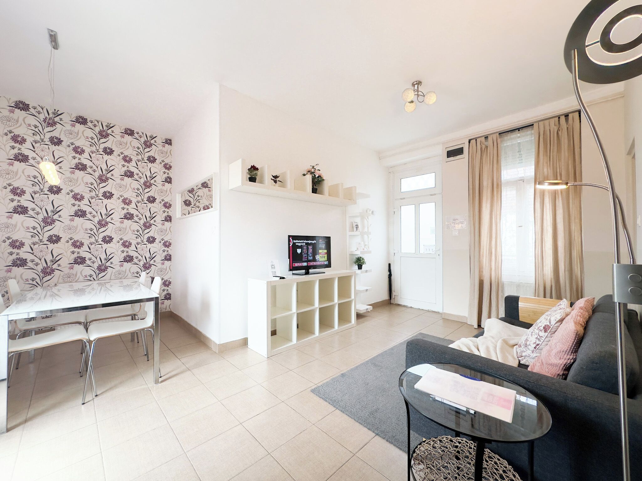 Ein modernes Wohnzimmer mit Essbereich, Fernseher und Sofa.