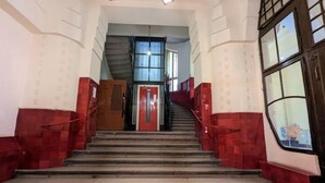 A staircase with red-tiled walls and a red door at the top.