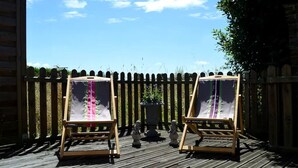 Two easels with canvases on a wooden deck, a wooden fence, and a clear sky. - In the heart of the Pays d'Auge, charming little house... (Livarot-Pays-d'Auge)