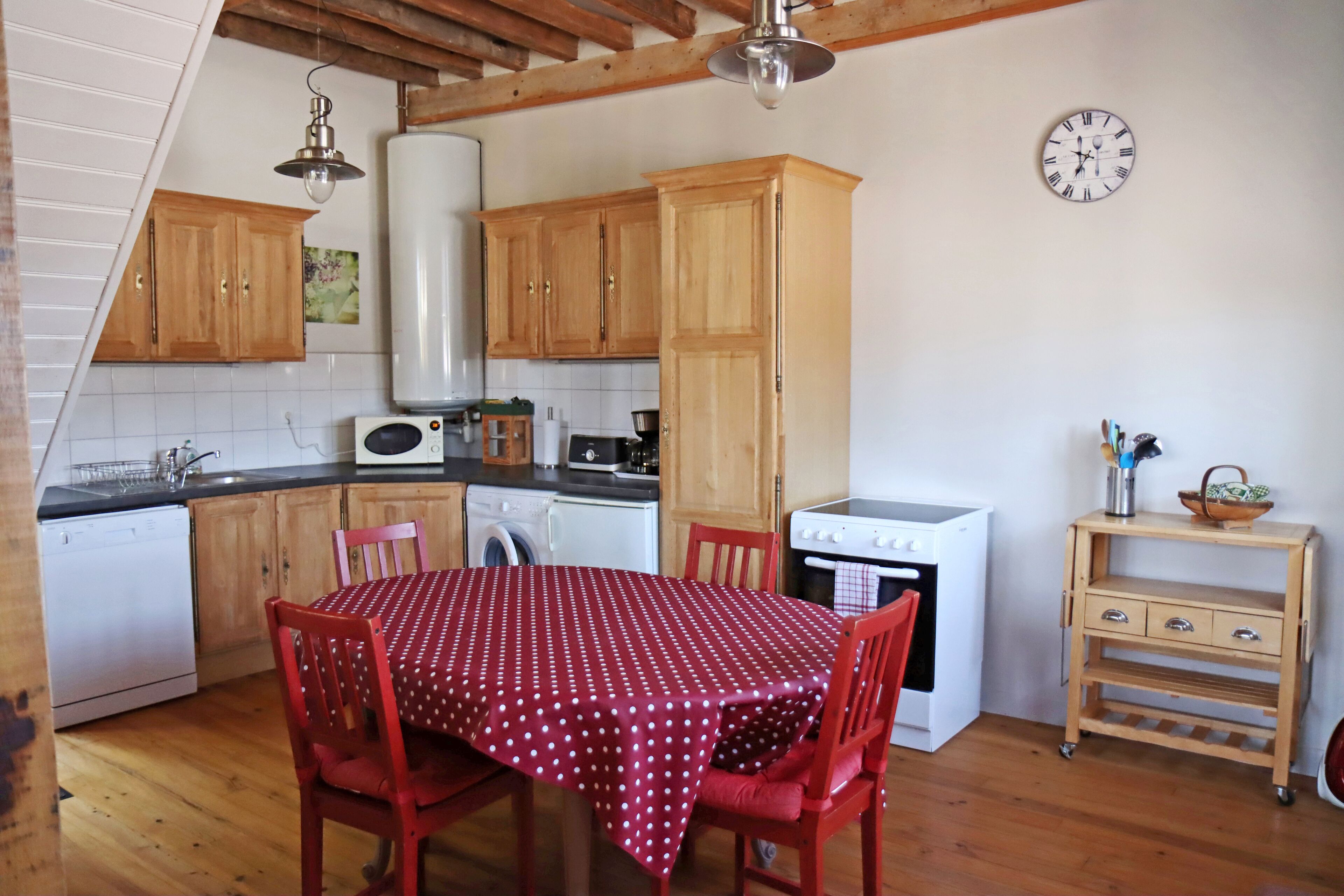 A kitchen with wooden cabinets, a microwave, a stove, and a dining table with chairs.