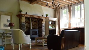 A living room with a fireplace, a television, and a sofa. - In the heart of the Pays d'Auge, charming little house... (Livarot-Pays-d'Auge)