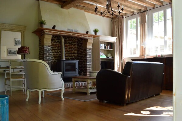 Una sala de estar con chimenea, televisor y sofá.