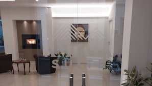 Een modern interieur met een open haard, een receptiebalie en potplanten.