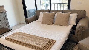 A bedroom with a bed, a window, a dresser, and a chair.