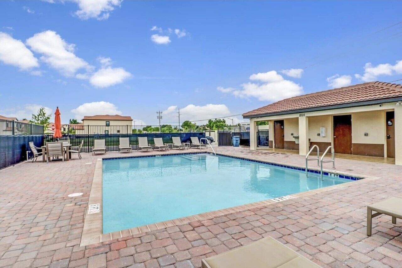 Una piscina con lettini e una zona relax coperta.