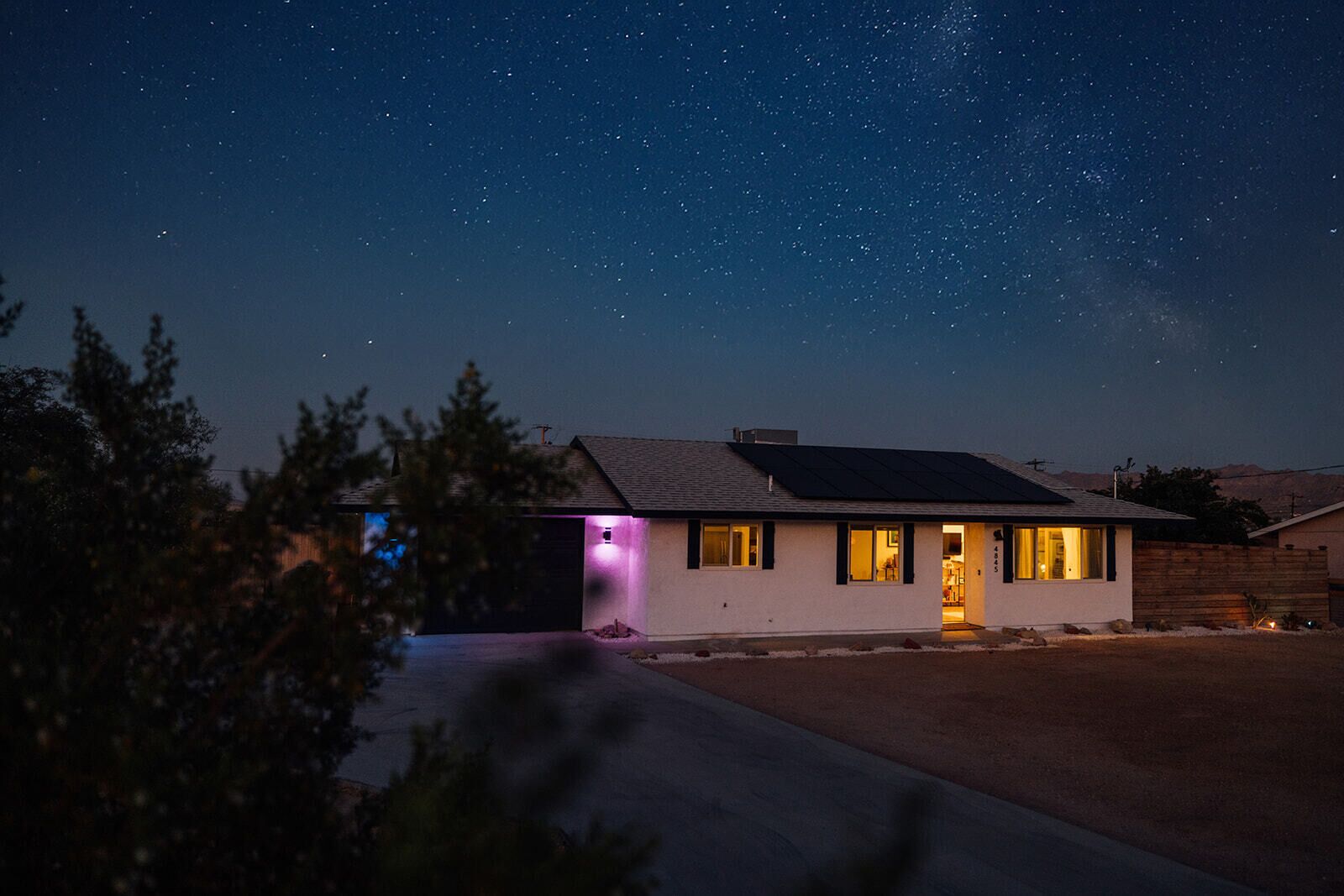 A house with a garage, a visible door, and a starry night sky.