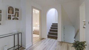 Ein Flur mit einer Treppe, die zu einem Schlafzimmer führt.