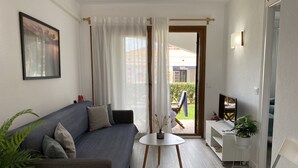 Een moderne woonkamer met een bank, een klein rond tafeltje en een televisie.