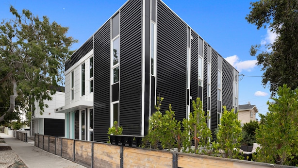 A modern building with a black and white facade, large windows, and a wooden fence. - Luminousness Reflection 4B2.5B Home (Torrance)