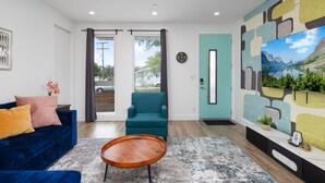 A modern living room with a blue sofa, teal armchair, and wooden coffee table. - Luminousness Reflection 4B2.5B Home (Torrance)