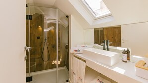 Ein modernes Badezimmer mit Oberlicht, Duschkabine aus Glas und großem Spiegel.