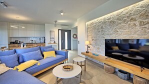 Ein modernes Wohnzimmer mit einer Couch, einem Couchtisch und einer Wand aus Stein.