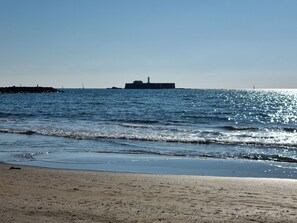 A beach with a lighthouse in the distance.