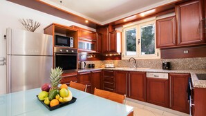 Una cocina moderna con electrodomésticos de acero inoxidable, armarios de madera y encimera de granito.