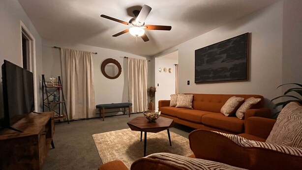 A living room with a ceiling fan, a sofa, a coffee table, and a TV. - Beautiful cozy2 bedrooms located in a safe community just minutes from downtown. (East Hartford)