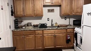 A kitchen with wooden cabinets, a granite countertop, a sink, a stove, and a refrigerator. - Beautiful cozy2 bedrooms located in a safe community just minutes from downtown. (East Hartford)