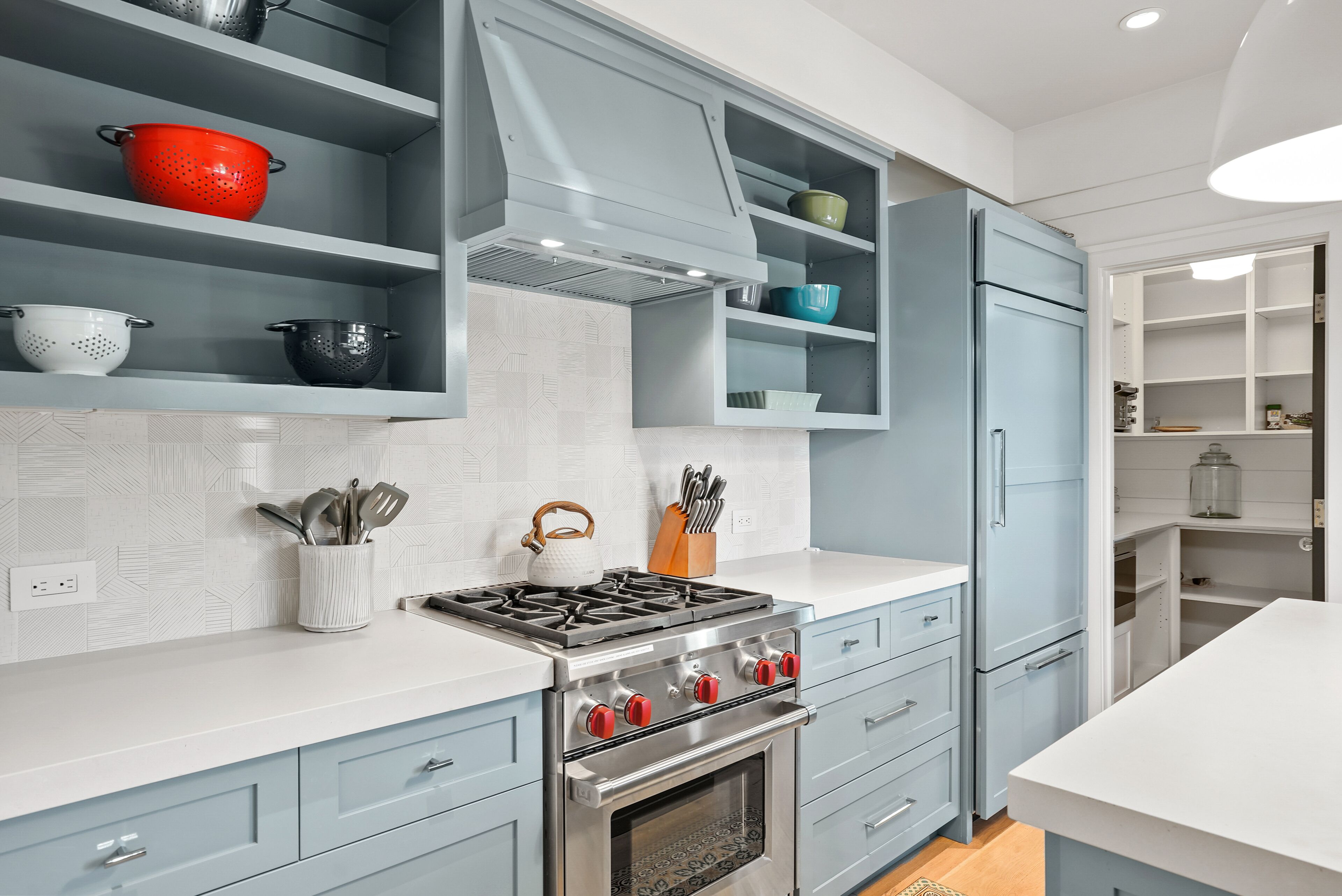 Una cocina moderna con estufa a gas, horno y armarios azules.