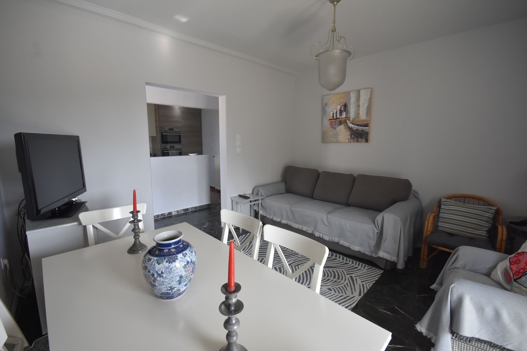 Ein modernes Wohnzimmer mit Esstisch, Sofa und Fernseher.