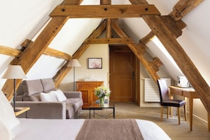 Une chambre confortable située dans les combles, avec un lit, un bureau et une chaise.