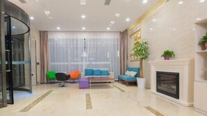 A modern living room with a fireplace, a sofa set, and a glass door entrance.
