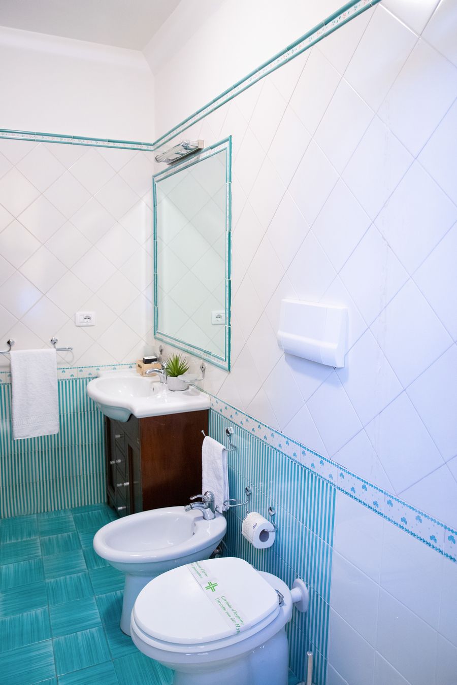 A bathroom with a toilet, bidet, and sink.