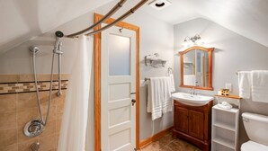 Ein Badezimmer mit Dusche, Waschbecken, Toilette und Spiegel.