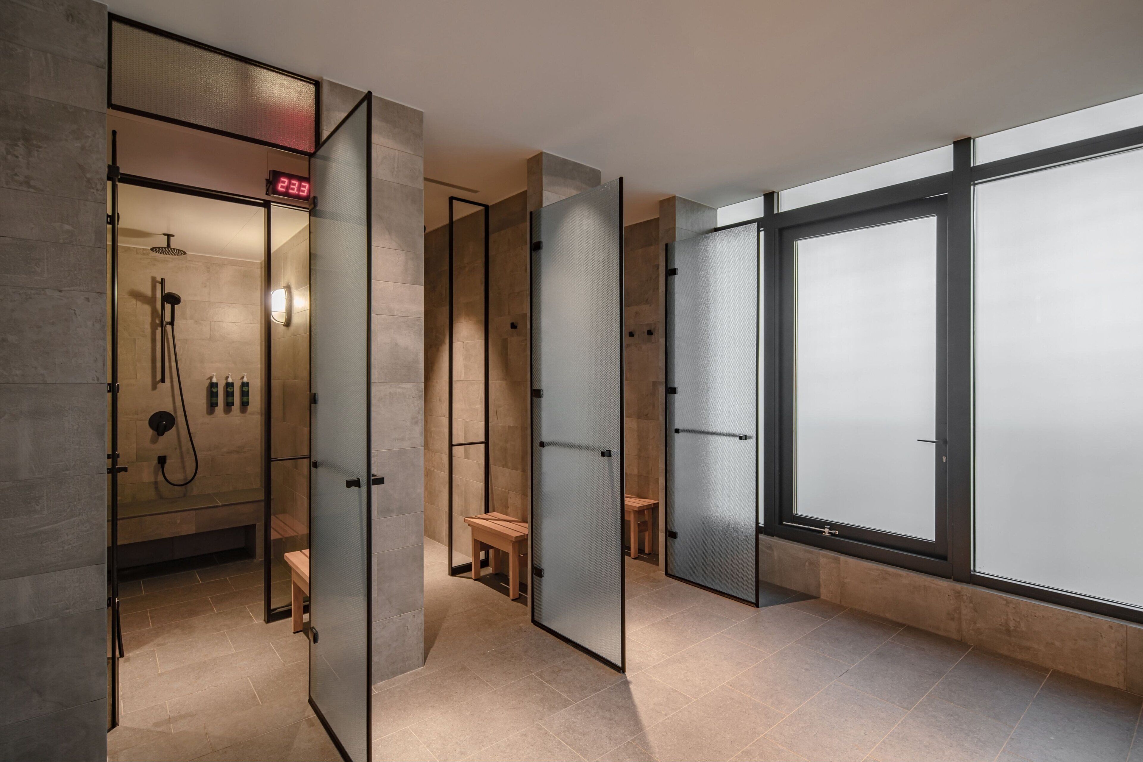 A modern bathroom with a glass partition, a shower area, and a bench.