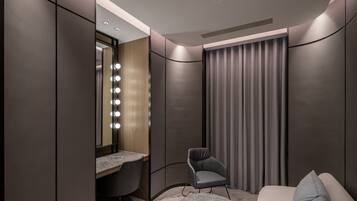 A modern bedroom with a vanity, a chair, and a bed.