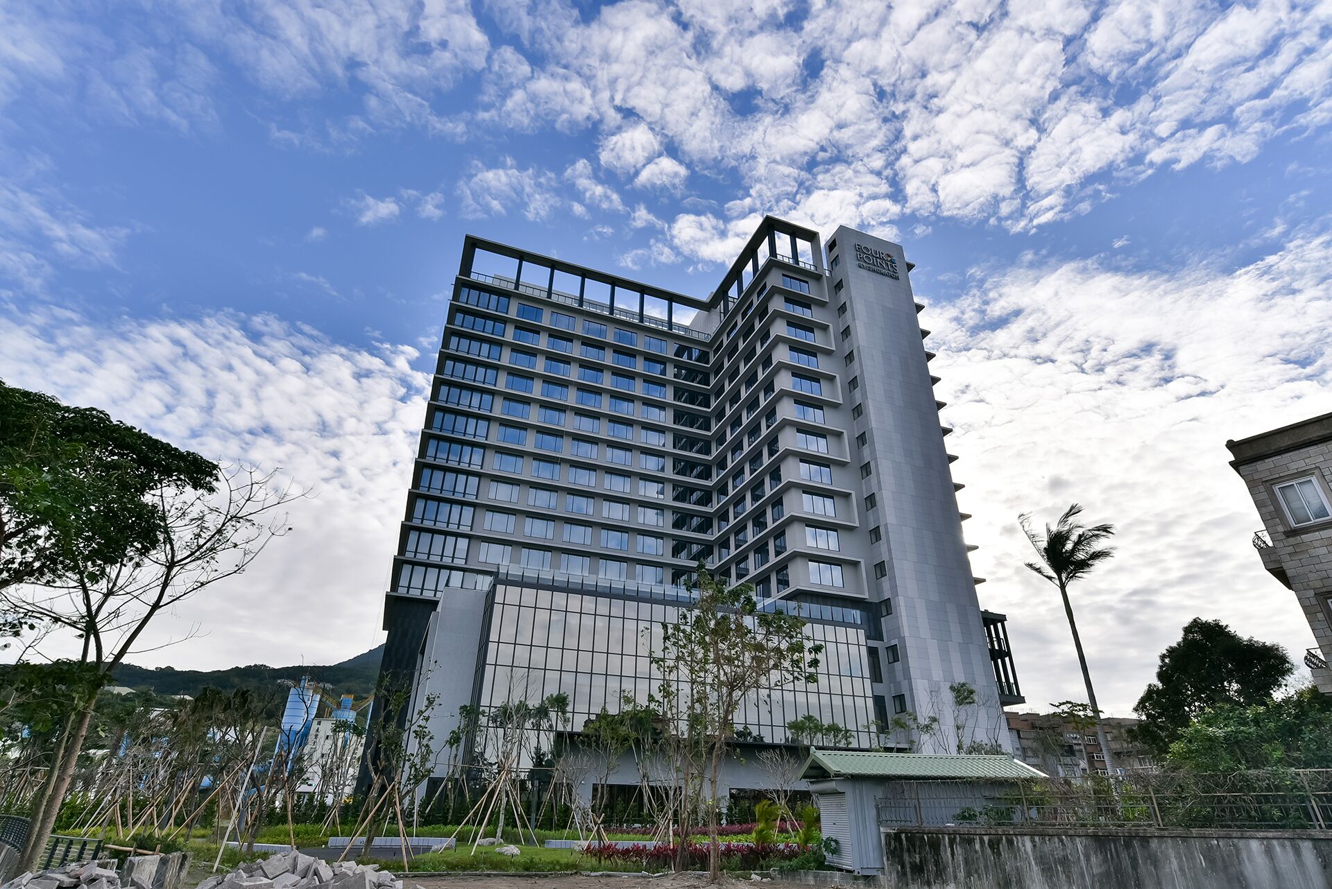 A modern multi-story building with a glass facade and a prominent vertical section.