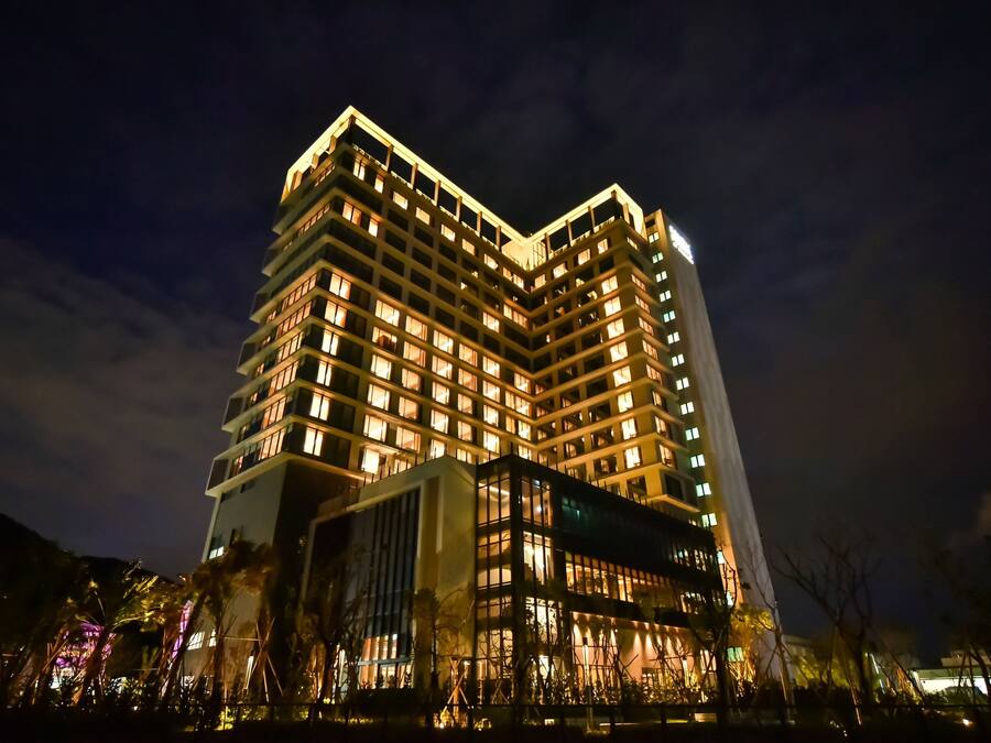 A multi-story hotel with illuminated windows and a prominent corner design.