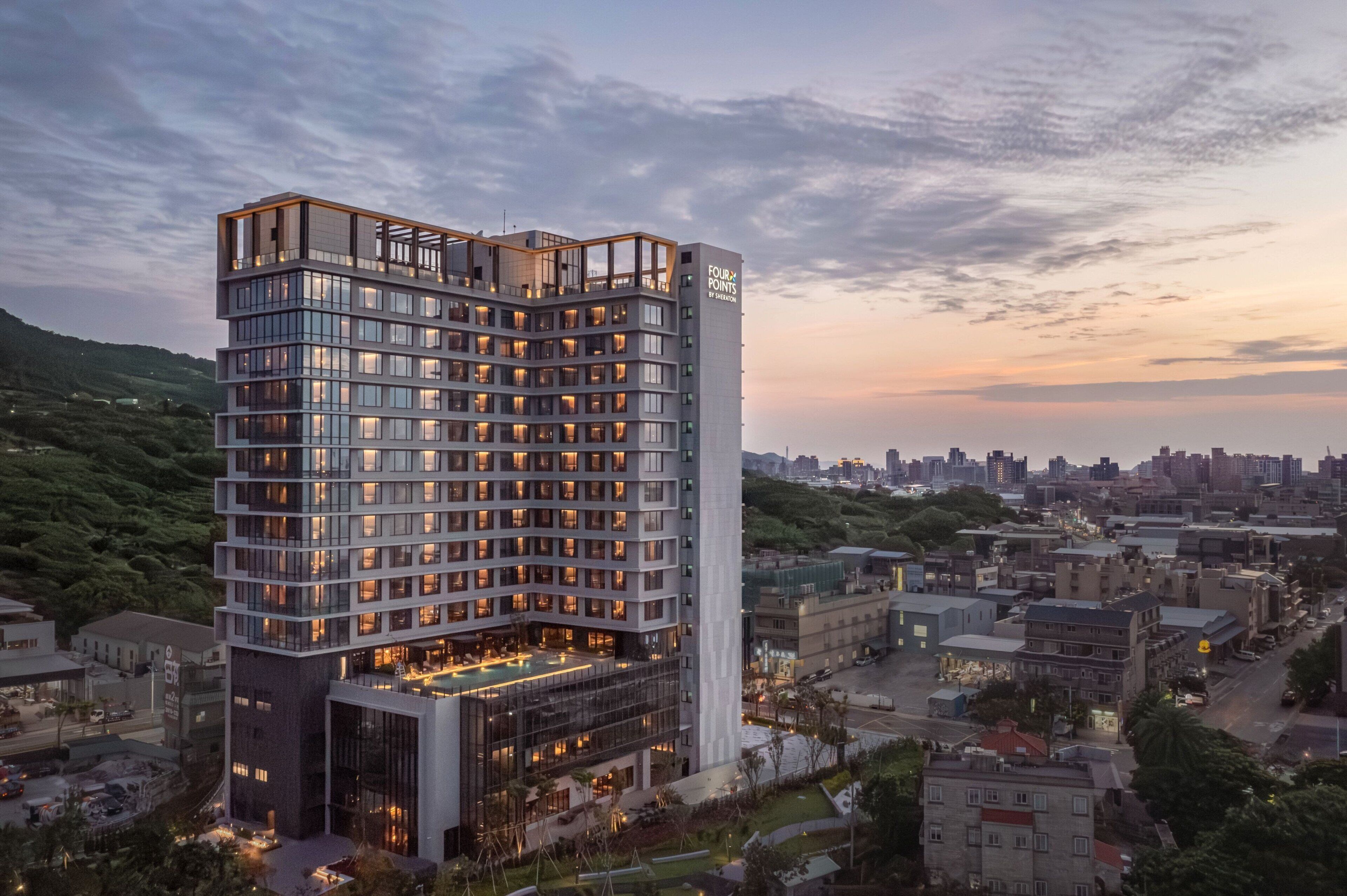 A modern hotel with multiple floors, large windows, and a prominent entrance area.