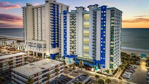 Um hotel com vários andares, design moderno, com varandas e grandes janelas.