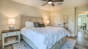 A bedroom with a bed, nightstands, a ceiling fan, and a large mirror. - Golfer's Haven! Gem w/ Patio & Grill in Sun City (Sun City)