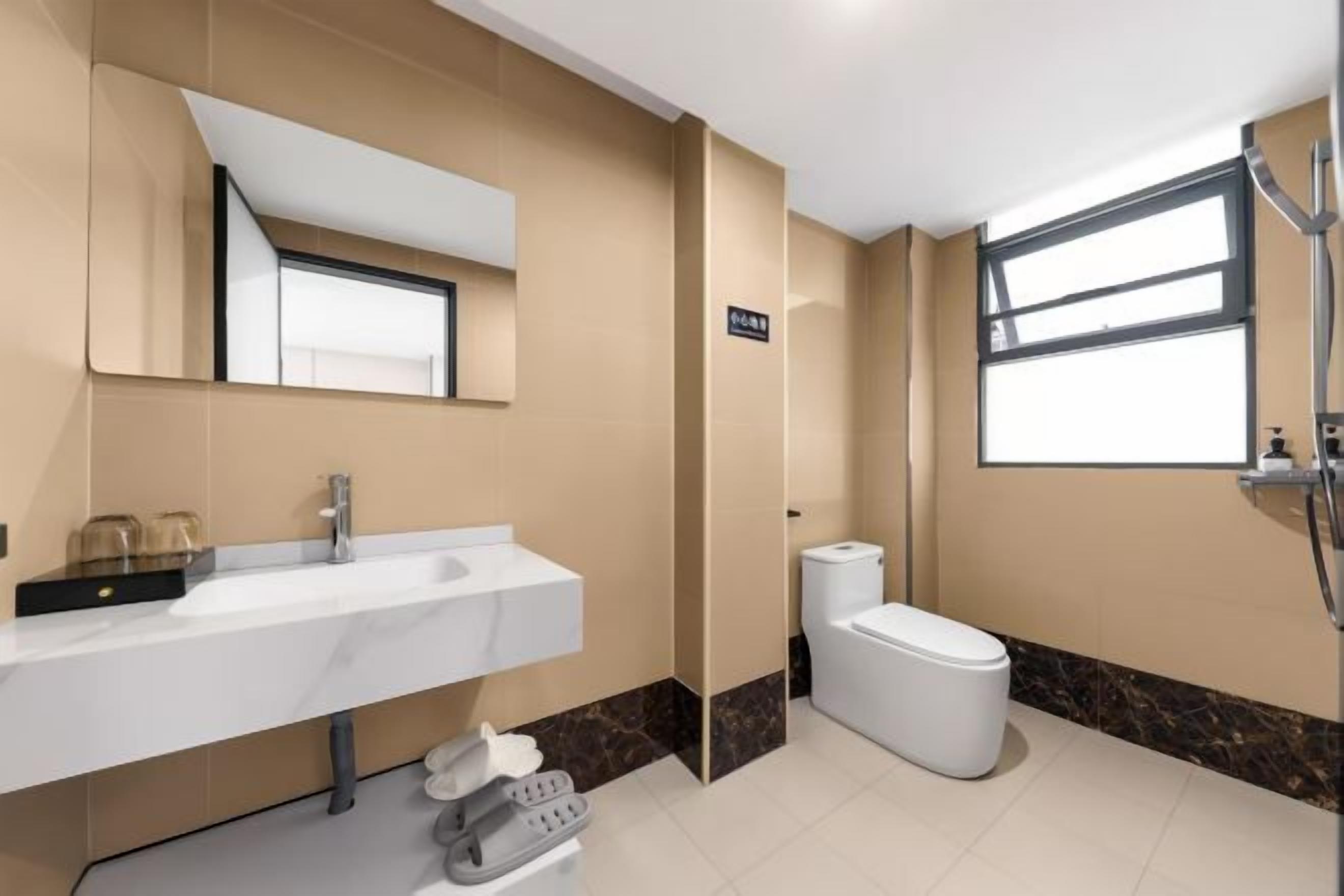 A modern bathroom with a white sink, mirror, and toilet.