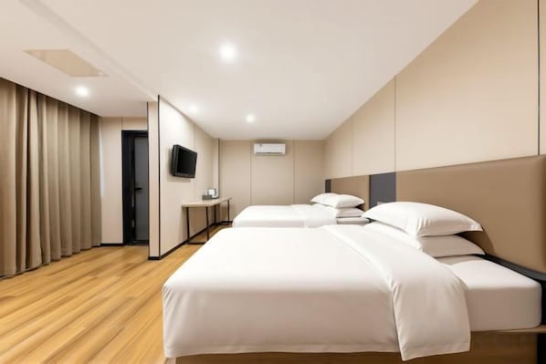 A hotel room with a large bed, a desk, a television, and a curtain. - Xingelin Business Hotel (Daye)