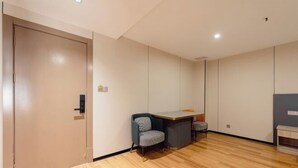 Una habitación con suelo de madera, un escritorio, una silla y un armario.