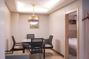 A conference room with a table, chairs, and a ceiling light fixture. - Xingelin Business Hotel (Daye)