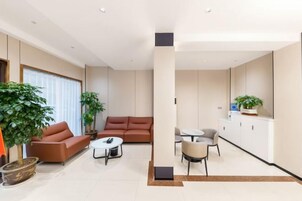 Una sala de estar moderna con sofá, mesa de centro y sillas, un comedor con mesa y sillas, y una cocina con armarios y encimera.