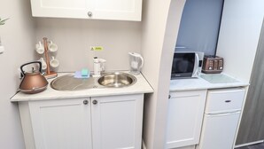 A compact kitchenette with a sink, kettle, toaster, and microwave. - Lockdown Lodge (Mablethorpe)