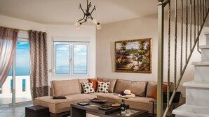 A living room with a sofa, coffee table, and a painting on the wall.