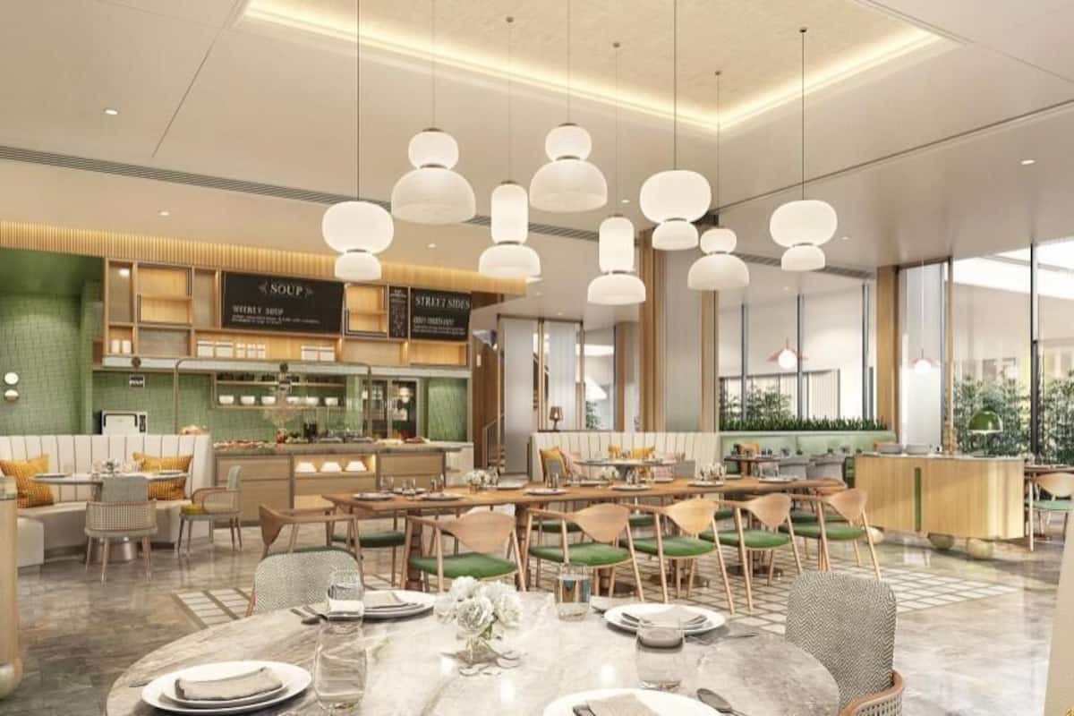 Un restaurante moderno con barra central, mesas de comedor e iluminación colgante.