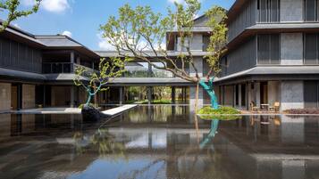 A modern building with a reflective water feature in the courtyard.